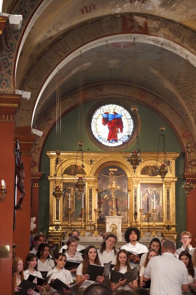 A group of people in a church with a stained glass window